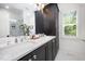 Bathroom featuring double vanity with white countertop, dark wood cabinets, and tiled shower at 200 W Corbin St, Hillsborough, NC 27278