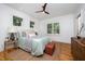 Cozy bedroom featuring wood floors, white walls, and ample natural light at 200 W Corbin St, Hillsborough, NC 27278