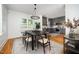 Dining room with black table and seating next to a kitchen with gray cabinets at 200 W Corbin St, Hillsborough, NC 27278