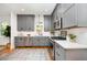 Modern kitchen with gray cabinets, stainless steel appliances, and quartz countertops at 200 W Corbin St, Hillsborough, NC 27278