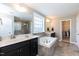 Elegant bathroom featuring a double vanity, soaking tub, tiled floors, and a walk-in closet at 2008 Campana Dr, Raleigh, NC 27603