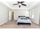 Spacious bedroom featuring tray ceilings, a ceiling fan, carpeted floors, and natural light at 2008 Campana Dr, Raleigh, NC 27603