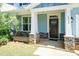 Inviting front porch with stone accents, leading to a dark wood front door and well-lit entry at 2008 Campana Dr, Raleigh, NC 27603