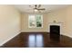 Bright and airy living room with a fireplace, fan, hardwood floors, and large windows overlooking the yard at 2008 Campana Dr, Raleigh, NC 27603