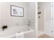 Well-maintained bathroom with tiled tub and shower, white walls, and a framed print at 202 Chapel Valley Ln, Apex, NC 27502