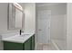 Bright bathroom featuring a green vanity with a white countertop and a large framed mirror at 202 Purvis St, Garner, NC 27529