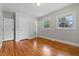 Bedroom with hardwood flooring, bright windows, and a door leading to the connected bath at 202 Purvis St, Garner, NC 27529