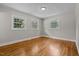 Bedroom featuring hardwood flooring, a light fixture, and multiple windows overlooking the yard at 202 Purvis St, Garner, NC 27529