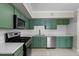 Kitchen showing stainless steel appliances, tile backsplash and trendy green cabinets at 202 Purvis St, Garner, NC 27529