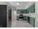 Well-lit kitchen showcasing stainless steel appliances and stylish green cabinetry at 202 Purvis St, Garner, NC 27529