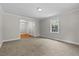 A large, carpeted living room has an entry to another room and a bright window with a lovely view at 202 Purvis St, Garner, NC 27529