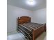 The bedroom features a wooden bed frame, and neutral carpeting at 2109 Star Sapphire Dr, Raleigh, NC 27610