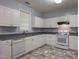 White cabinets, gray countertop, and marble style floors are featured in this kitchen at 2109 Star Sapphire Dr, Raleigh, NC 27610