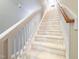 Carpeted stairway with white banisters, leading to the upper level of the home at 2109 Star Sapphire Dr, Raleigh, NC 27610
