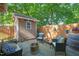 Outdoor patio with comfortable seating, a modern fire pit, and privacy fence with lush plants at 211 W Trinity Ave, Durham, NC 27701