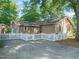 A fenced backyard features a gravel area and a patio with outdoor seating, enhanced by string lights at 211 W Trinity Ave, Durham, NC 27701