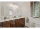 Bathroom featuring a double sink vanity with wood cabinets and white countertops and two mirrors at 211 W Trinity Ave, Durham, NC 27701