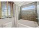 Bathroom featuring a white tiled tub and shower with a window letting in natural light at 211 W Trinity Ave, Durham, NC 27701