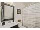 Well-lit bathroom showcasing a decorative framed mirror, a vanity, and a shower with curtain at 211 W Trinity Ave, Durham, NC 27701