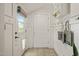 Bright mud room with white walls, tiled flooring, a window, and coat hooks at 211 W Trinity Ave, Durham, NC 27701