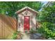 Charming outdoor shed with red door, birdhouse, and mature landscaping at 211 W Trinity Ave, Durham, NC 27701