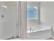 Bathroom featuring a separate shower and soaking tub with window for natural light at 2123 Scarlet Sage Dr, Durham, NC 27704