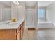 Bright bathroom featuring a double vanity, a soaking tub under a window, and a separate glass-enclosed shower at 2123 Scarlet Sage Dr, Durham, NC 27704