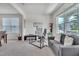 Well-lit home office with a glass desk, comfortable gray sofa, and large windows for natural light at 2123 Scarlet Sage Dr, Durham, NC 27704