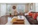 An open living room with a brown sofa, hardwood floors, and natural light at 215 Brier Summit Pl, Durham, NC 27703