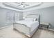 Main bedroom boasts a tray ceiling, carpeted floor, and an abundance of natural light at 215 Brier Summit Pl, Durham, NC 27703