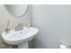 Stylish pedestal sink and mirror in a well-lit powder room at 215 Brier Summit Pl, Durham, NC 27703