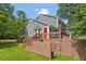 Back exterior featuring a wooden deck, gray siding, and lush greenery at 2208 Pathway Dr, Chapel Hill, NC 27516