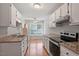 Well-lit kitchen featuring granite countertops, white cabinets, and modern stainless steel appliances at 2208 Pathway Dr, Chapel Hill, NC 27516