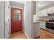 Hallway entrance to kitchen with granite counters, stainless appliances, and a red front door at 2208 Pathway Dr, Chapel Hill, NC 27516
