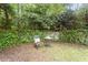 Serene backyard area featuring a decorative chair and table against a stone wall at 2406 Oxford Rd, Raleigh, NC 27608