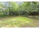 Well-maintained backyard with lush greenery and a stone retaining wall at 2406 Oxford Rd, Raleigh, NC 27608
