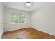 Bedroom with hardwood floors, neutral walls, and a large window overlooking backyard at 2406 Oxford Rd, Raleigh, NC 27608