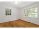 Bedroom with hardwood floors, large windows, and bright, neutral walls at 2406 Oxford Rd, Raleigh, NC 27608