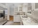 Bright kitchen featuring granite countertops, white cabinets, stainless steel appliances, and a neutral tile floor at 2406 Oxford Rd, Raleigh, NC 27608
