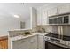 Modern kitchen with white cabinetry, stainless steel appliances, granite countertops, and an eat-in bar at 2406 Oxford Rd, Raleigh, NC 27608
