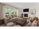 Bright living room featuring a fireplace, neutral furniture, hardwood floors and large windows overlooking a beautiful yard at 2406 Oxford Rd, Raleigh, NC 27608