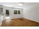 Bright room with hardwood floors, large windows, and a door to the backyard at 2406 Oxford Rd, Raleigh, NC 27608