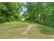 Backyard with a shed and lawn surrounded by mature trees at 2410 Huron St, Durham, NC 27707