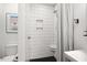 Bathroom with white tile walls, shower, toilet, and classic Campbell's soup art at 2410 Huron St, Durham, NC 27707