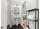 This bathroom has a pedestal sink, an adjacent shower, and shelving for linens at 2410 Huron St, Durham, NC 27707