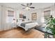 Bright bedroom featuring hardwood floors, a ceiling fan, and a queen-sized bed with natural light at 2410 Huron St, Durham, NC 27707
