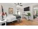 Bright bedroom featuring hardwood floors, a ceiling fan, and a queen-sized bed with workspace at 2410 Huron St, Durham, NC 27707