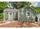 Charming home featuring a quaint porch, inviting gray front door, and pleasant green siding at 2410 Huron St, Durham, NC 27707