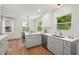 Kitchen with gray cabinets, quartz countertops, stainless appliances, wood floors and natural light at 2410 Huron St, Durham, NC 27707