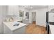 Well-lit kitchen featuring gray cabinets, quartz countertops, a modern faucet and rustic hardwood floors at 2410 Huron St, Durham, NC 27707